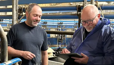 John Fra Smartfarming Tjekker Data På Et Besætningsbesøg